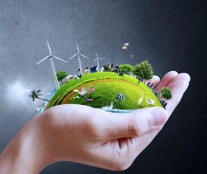 A person holding an earth with wind mills in the background.